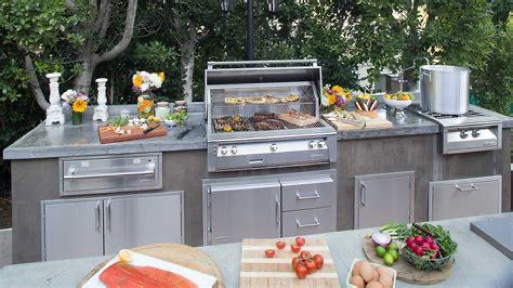 Alfresco ALXE built-in gas grill in a stainless outdoor kitchen island